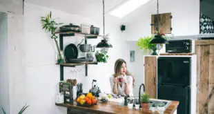 young woman in her custom designed kitchen with modern white and rustic wood