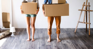 couple moving in with boxes in hands